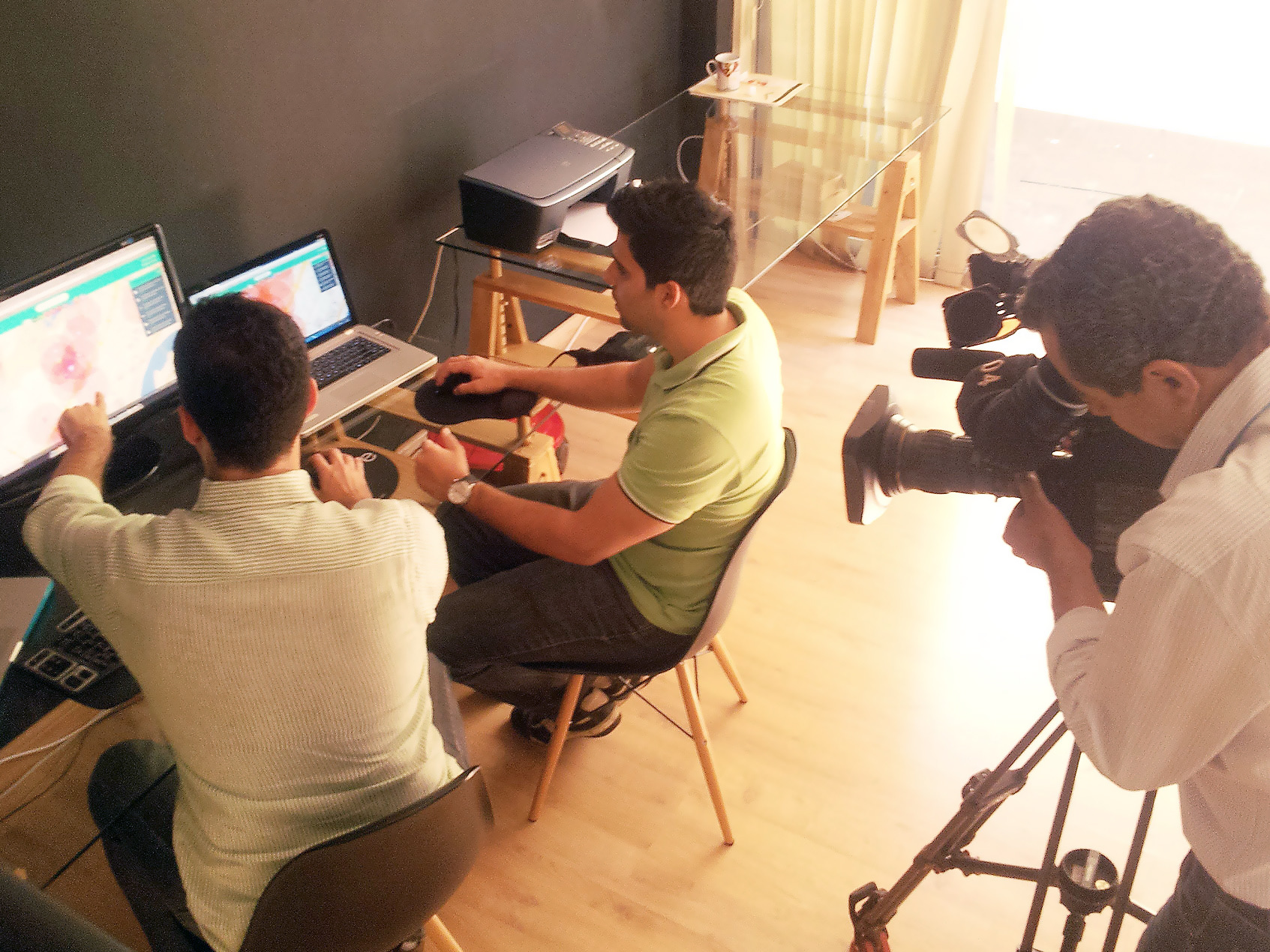 A TV crew filming a news segment about Radarea, with the app open on two monitors in the studio