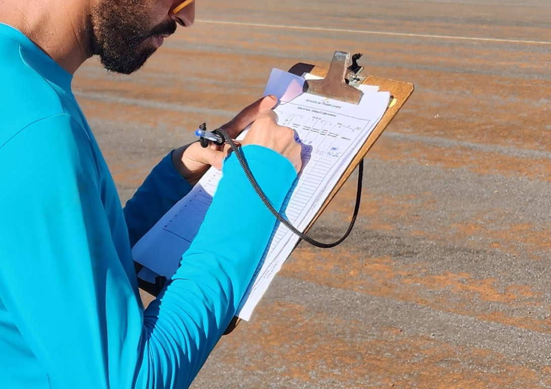 Coordinator filling in flight data by hand next to the runway